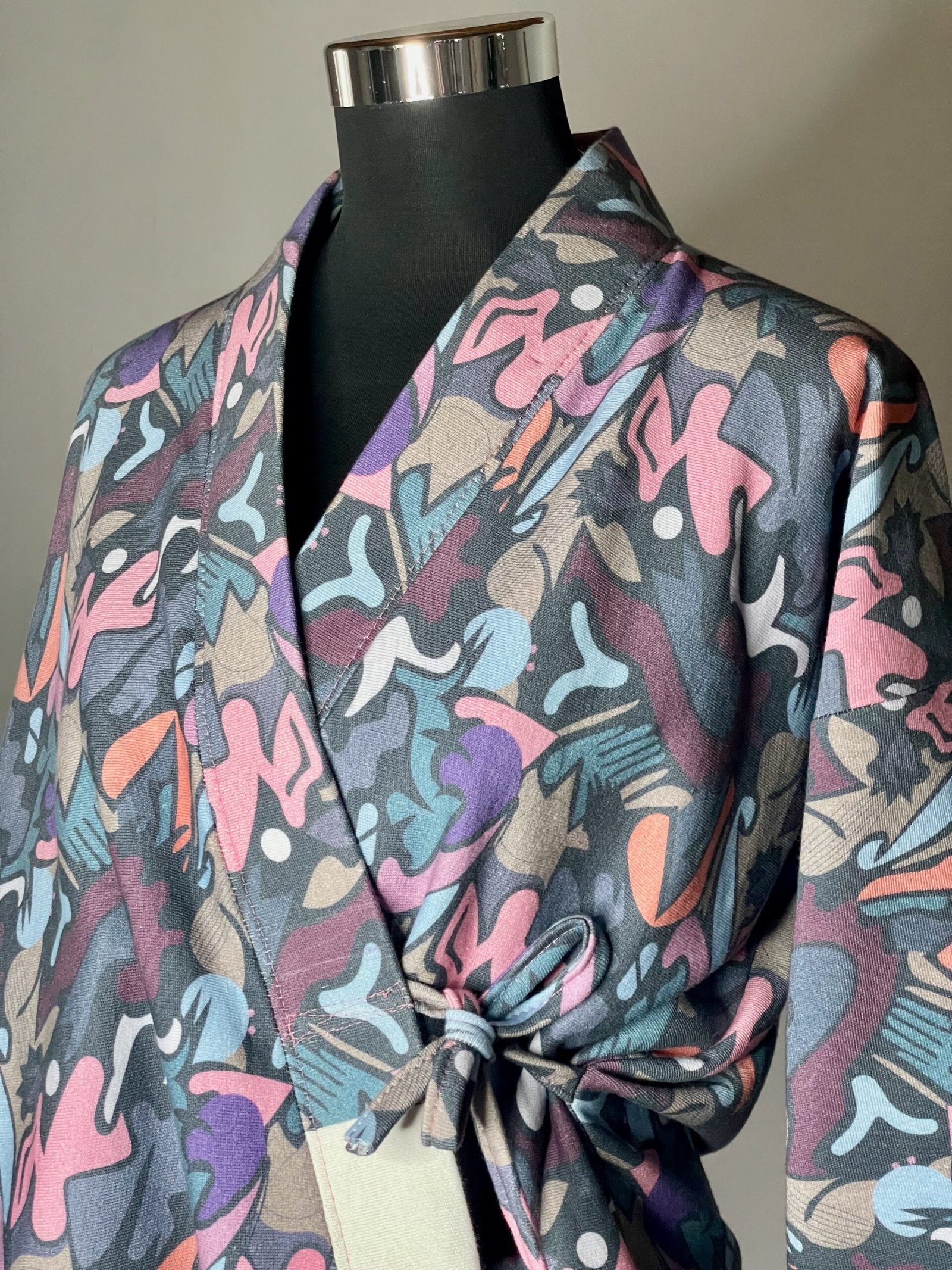 img 0869 Une veste pour femme avec un imprimé coloré, nouée avec des lanières. Parfaite pour ajouter une touche de style à votre tenue ! Motif Graffiti multicolore
