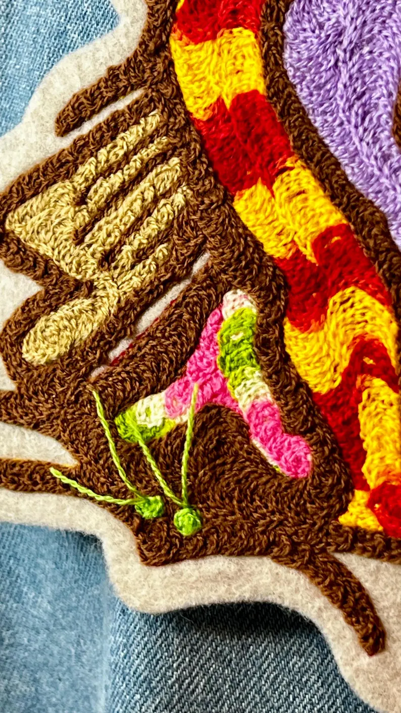 il 794xn.6380370708 6tht.jpg Ce patch coloré est magnifique. La broderie au point de chaîne ajoute une touche artisanale unique et une texture intéressante. Ce patch est un véritable chef-d’œuvre avec ses couleurs vives et sa broderie au point de chaîne.