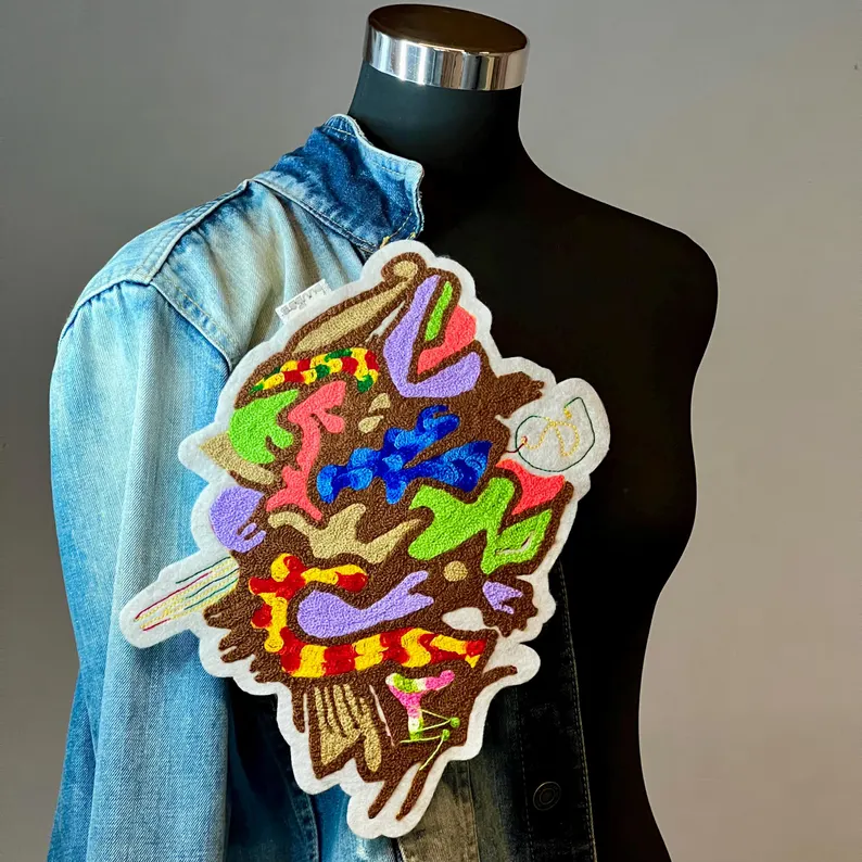 il 794xn.6428473971 azgu.jpg Un patch brodé aux motifs graffiti apporte une touche de couleur à cette veste en jean.